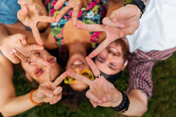Obraz premium happy young company of friends sitting park