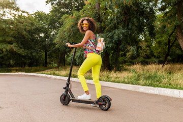 young stylish black woman having fun in park riding on electric kick scooter © mary_markevich