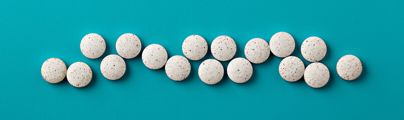 white pills on blue background. white dietary supplements banner
