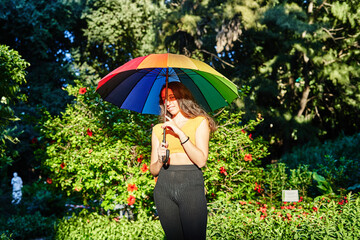 girl with rainbow umbrella in the park LGBT concept