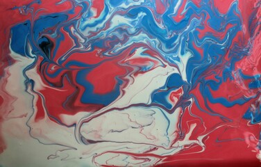 Abstract background of blue-red-white marble. Acrylic paint mixes freely and creates an interesting pattern. Bright saturated shades. Background for the cover of a laptop, laptop.