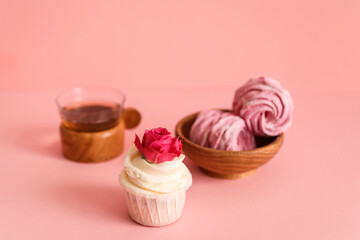 Delicious sweets and cup of tea on the pink background.