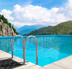 Outdoor swimming pool at luxury resort and beautiful view of mountains on sunny day