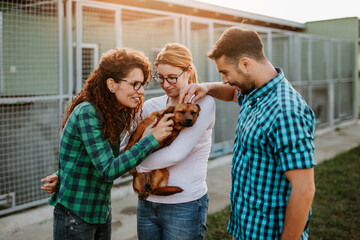 Young good looking couple wants to adopt beautiful dog at animal shelter.