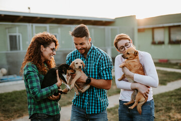 Young good looking couple wants to adopt beautiful dog at animal shelter.