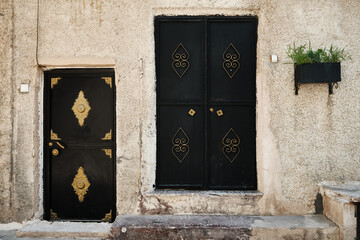 Entrance doors of traditional middle eastern stone house. Metal doors decorated with copper colored...