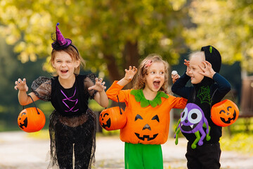 Happy Halloween. three running kids with a basket for sweets