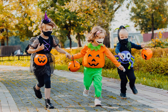 Happy Halloween. three running kids with a basket for sweets