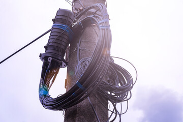 A fiber optic cable harness for communication weighs on a concrete column. Telecommunications and...