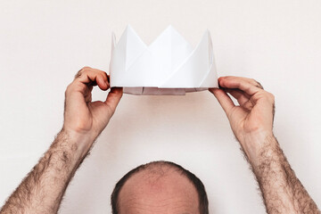 man and a white paper crown. The man is offered a crown. hands hold crown over head. Coronation...