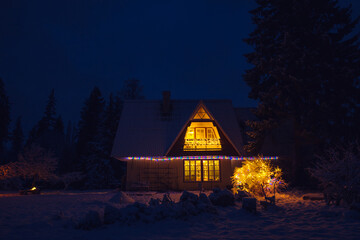 Cute decorated vintage country house home in the middle of forest at night. Tranquil Christmas Eve...