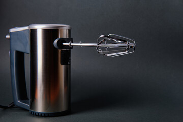 Electric mixer on a dark background, side view