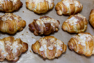 Freshly baked flavored with white chocolate and nuts croissant. Sweet handmade dessert with almond