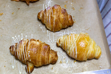 Baker decorating freshly baked croissant. Sweet handmade dessert