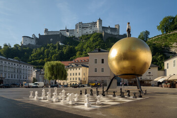 Golden Sphaera ball on Kapitelplatz in the old town of Salzburg with the Hohensalzburg castle on...
