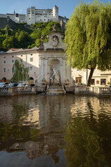 Fototapeta na wymiar Neptune Fountain on Kapitelplatz in the baroque old town of Salzburg, Austria