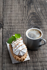 Shortcrust pastry with meringues and toffee filling on wooden table