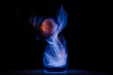burning sambuca glasses on a black background with a purple flame