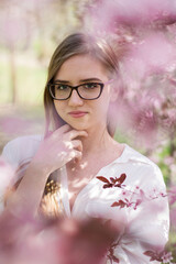 portrait of a woman in glasses among pink flowers © ms16_photo