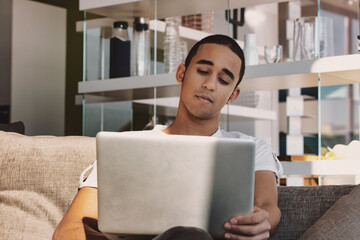 Young man watching media or reading on a laptop computer