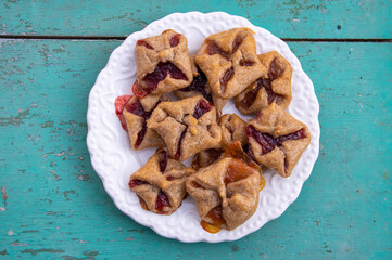Czech cheesecake pastry folded cubes baskets biscuits wrapped filled with red jam on rustic scratched vintage background