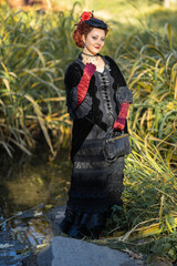 Women in costumes of the 19th century against the background of nature in the spring in the park