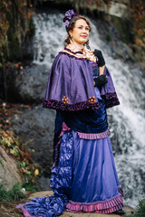 Women in costumes of the 19th century against the background of nature in the spring in the park