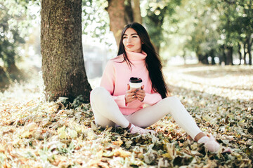 Beautiful woman drink coffee sitting in the park.