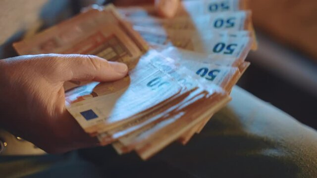 Hands of financial broker counting dirty money, banking agent holding stack of euro banknotes in hands. Person calculate illegal earnings, corruption, fraud and money laundering concept