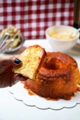 Fatia de bolo pudim na mão