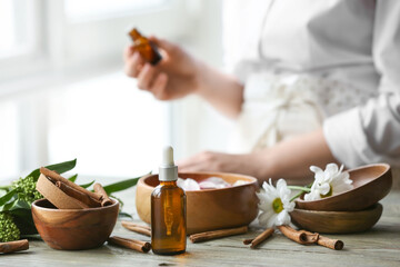 Bottle of cinnamon essential oil on table - obrazy, fototapety, plakaty