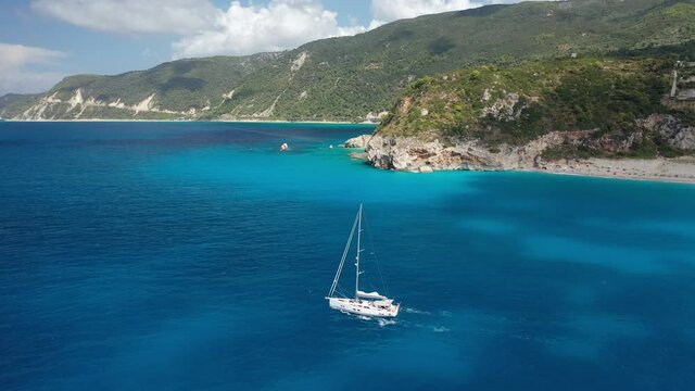 Aerial drone video of iconic beach and bay of Milos with turquoise clear sea in island of Lefkada, Ionian, Greece