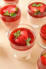 Glasses with delicious strawberry panna cotta on color background, closeup