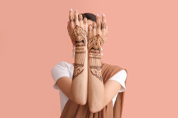 Beautiful Indian woman with henna tattoo on color background