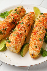 Plate with tasty Elote Mexican Street Corn on white wooden background, closeup