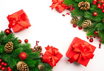 White Christmas and New Year background with red gift boxes, Christmas balls, spruce branches, cones and berries. Top view frame with copy space