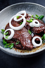 Modern style traditional Cuban dry aged angus bistec encebollado steak with onion rings in soy...