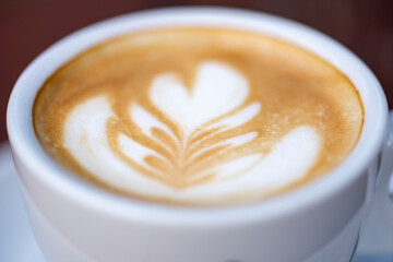 White cup of espresso coffee on wooden table. Space to copy your text.