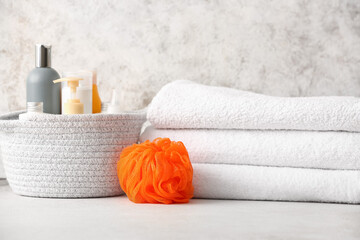 Obraz na płótnie Canvas Clean towels, cosmetics and sponge on table