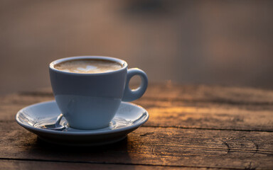 White cup of espresso coffee on wooden table. Space to copy your text.