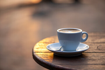 White cup of espresso coffee on wooden table. Space to copy your text.