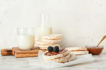 Puffed rice crackers, blackberry and melted chocolate on light background