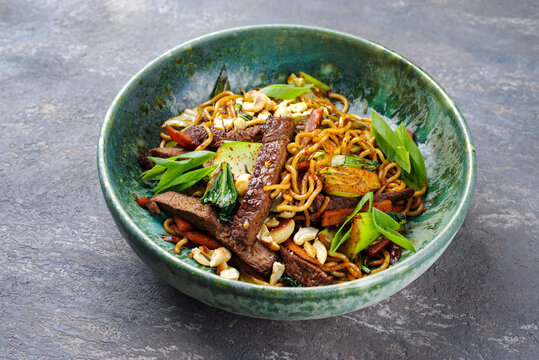 Modern style pad Thai beef with angus roast beef slices, noodles and vegetable served as close-up in a Nordic design bowl