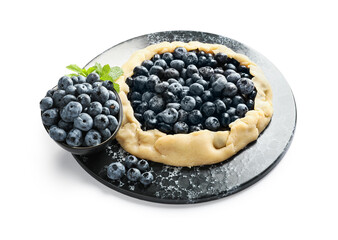 Plate with raw blueberry galette on white background