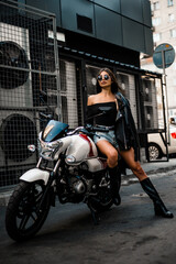 Obraz na płótnie Canvas Pretty young sexy fashion model posing on the motorcycle.