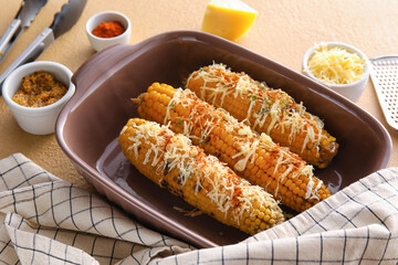 Baking dish with delicious Elote Mexican Street Corn on beige background
