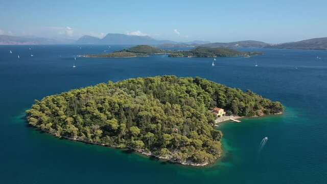 Aerial drone video of iconic uninhabited island of Madouri in bay of Nydri and Mansion of 19th-century poet Aristotelis Valaoritis, Lefkada island, Ionian, Greece