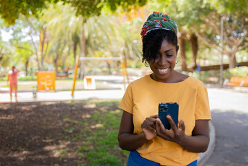 young african american woman laughing typing a message on the mobile phone