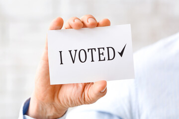 Man holding paper with text I VOTED, closeup