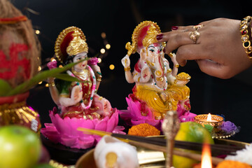 Hands Of Girl Applying Roli Tilak On Forehead Of Ganpati Bappa Morya While Worshiping Maa Lakshmi &...